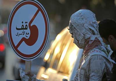 أحد المتضامنين مع أسرى الأمعاء الخاوية مرتديًا ما يشبه زي الأسرى داخل سجون الاحتلال
